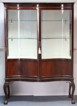 A late Victorian mahogany serpentine-front glazed display cabinet, fitted two glass shelves, with