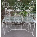 A white painted wrought-iron garden table on four shaped legs with tubular stretchers & a glass top,