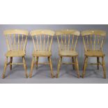 A set of four spindle-back kitchen chairs each with a hard seat, & on turned legs with turned