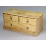 A pine dwarf chest fitted two short & one long drawer & on turned knob handles, & on a plinth