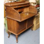 An early 20th century small oak writing desk with a fitted interior enclosed by a tambour shutter