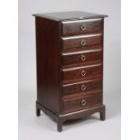 A Stag “Minstrel” mahogany-finish upright chest fitted six long drawers with brass ring handles, & a