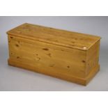 A pine blanket box with a hinged lift-lid; & on a plinth base, 122cm wide x 49.5cm high x 46.5cm
