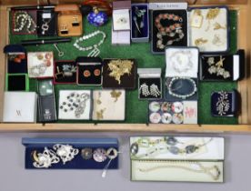 Various items of costume jewellery, contained in a glazed wooden counter-top case.