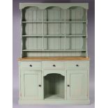 A light-green painted & natural pine dresser, the upper part with three open shelves with a panelled