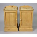 A pair of pine tray-top bedside cupboards each fitted centre shelf enclosed by a panel door, & on