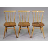 A set of three Ercol spindle-back kitchen chairs each with a hard seat, & on round tapered legs with