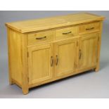 A light oak sideboard fitted three frieze drawers above cupboard enclosed by three panel doors,