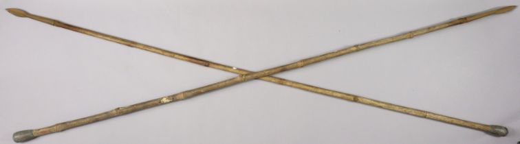 A pair of vintage eastern spears each with a bamboo handle, 214cm long.