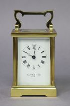 A modern English brass carriage timepiece with fluted corners, the white enamel dial with black