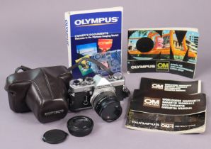 An Olympus “OM-1” camera with various accessories.