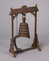 A Burmese cast-bronze table bell on a cast-iron stand (with beater), 25cm wide x 36.5cm high.