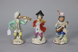 A set of three continental-style porcelain novelty monkey character musician figures, 28cm, 27.5cm &