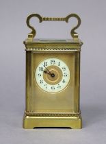 A late 19th/early 20th century brass carriage timepiece, the gilt dial with black Arabic numerals to