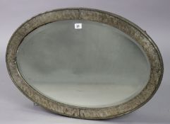 An Art Nouveau-style oval wall mirror in a silvered-metal frame & inlaid with a bevelled plate, 53cm