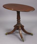 A 19th century mahogany oval tripod table with an oval top, & on a vase-turned centre column &