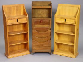 A mid-20th century oak small standing bookcase cupboard fitted two open shelves above a fall-front &