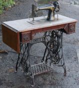 A vintage Singer treadle sewing machine in an oak case, & on a black painted cast-iron base, 88cm
