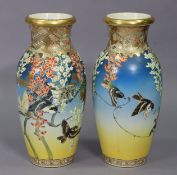 A pair of Japanese pottery ovoid vases of blue & yellow ground, & with multi-coloured floral &
