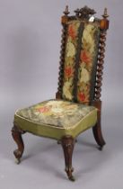 A 19th century carved mahogany-frame nursing chair with a padded seat & back upholstered multi-