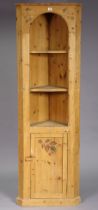 A pine tall standing corner cabinet with painted vine-leaf decoration, having two shaped open