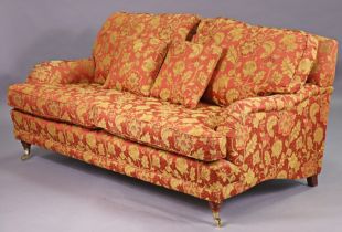 A Victorian-style three-seater settee upholstered crimson & gold floral material, & on short