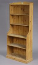 A pine tall standing six-tier open bookcase with shaped end supports, & on a plinth base, 71cm