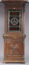 A 19th century carved oak tall cabinet the upper part fitted three shelves enclosed by a leaded