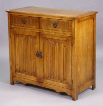 A small oak side cabinet fitted two frieze drawers above a pair of linen-fold panel doors, 95cm wide