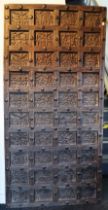 An African hardwood architectural panel all-over carved with vignettes of figure scenes, animals,