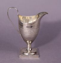 A George III silver helmet-shaped cream jug with pricked decoration, loop handle, & on square