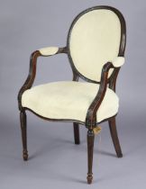 A George III mahogany elbow chair in the French style, with carved decoration, padded oval back,