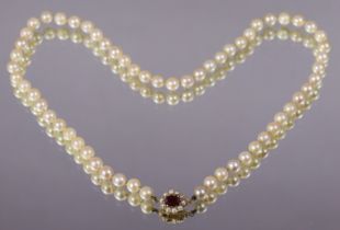 A single-row necklace of sixty cultured pearls of near uniform size. the 9ct. gold clasp set oval