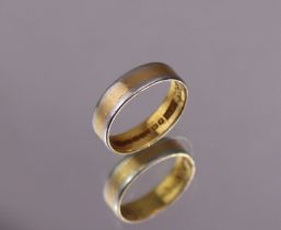 A 22ct. gold band with platinum edges; size: J/K. (3.6gm).