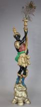 An early 20th century Venetian polychrome torchere, the figural support standing on a carved rocky