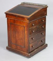 An early 19th century rosewood davenport, the forward-sliding top with brass gallery & long hinged