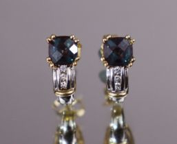 A pair of synthetic alexandrite earrings, the oval stones set above trios of graduated round-cut