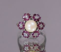 A pearl, ruby, & diamond ring, the central cultured pearl approx. 6mm dia., set within a border of