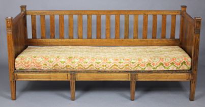 A French mahogany day-bed with open rail back, panelled sides & long squab cushion, on reeded