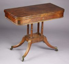 A Regency rosewood & brass inlaid card table with rounded corners to the rectangular fold-over