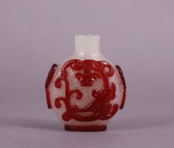 A 20th century overlaid-glass snuff bottle, carved with chimera & mask-handles through ruby-red to a