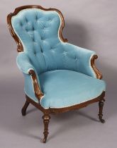 A Victorian rosewood easy chair with buttoned back, padded seat & arms upholstered blue velour, on