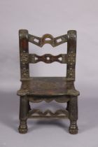 A 20th century North African hardwood small chair with all over carved decoration & embossed metal