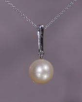 A freshwater pearl & diamond pendant, the pearl approx. 10mm dia., suspended from a white metal loop