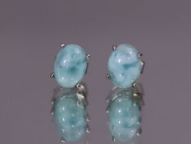 A pair of larimar ear-studs, the oval cabochons set to un-marked white metal mounts. (1.7gm).