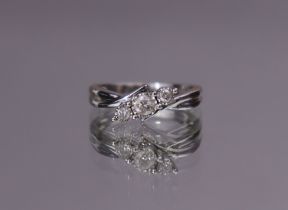 A three-stone diamond ring, the graduated stones set at an angle to a 9ct white gold shank; size: K;