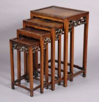 A late 19thearly 20th century Chinese hardwood nest of four occasional tables, each with carved &