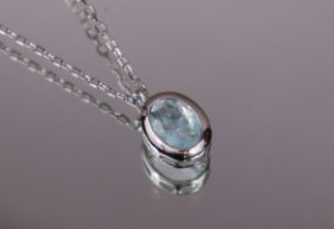 A pale blue topaz pendant, the oval-cut stone set in silver rub-over mount, on silver fine-link