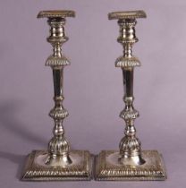 A pair of Old Sheffield plate candlesticks, the slender tapered octagonal columns with gadrooned
