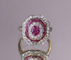 AN ART DECO STYLE RUBY & DIAMOND RING, the rectangular panel with canted corners set centre ruby